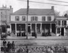 Black and white photo of buildings located at 812-814 East Broad Street. Mitchell moved his printing office to the main building in the image, built around 1791 and formerly home to the Swan Tavern, and operated out of two basement rooms.